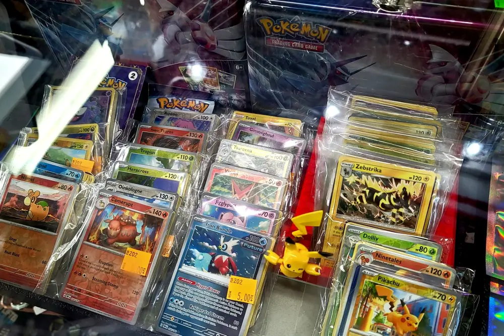Pokémon trading cards laid out under glass in the display counter